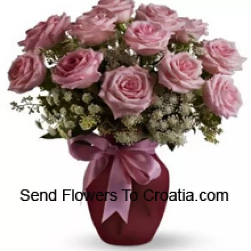 11支粉色玫瑰与各种白色填充物放在玻璃花瓶中